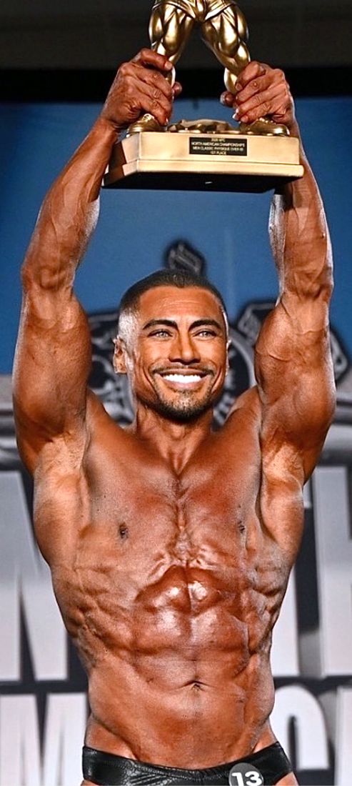 Dr. Suarez holding a first-place bodybuilding trophy